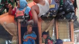 Personel TNI membantu mengevakuasi warga, termasuk anak-anak dan ibu membawa bayi, menggunakan perahu karet di wilayah yang terdampak banjir.
