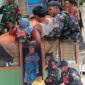 Personel TNI membantu mengevakuasi warga, termasuk anak-anak dan ibu membawa bayi, menggunakan perahu karet di wilayah yang terdampak banjir.
