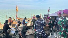 Prajurit Marinir TNI AL menyalurkan bantuan logistik menggunakan kapal nelayan di Aceh Tamiang.