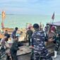 Prajurit Marinir TNI AL menyalurkan bantuan logistik menggunakan kapal nelayan di Aceh Tamiang.