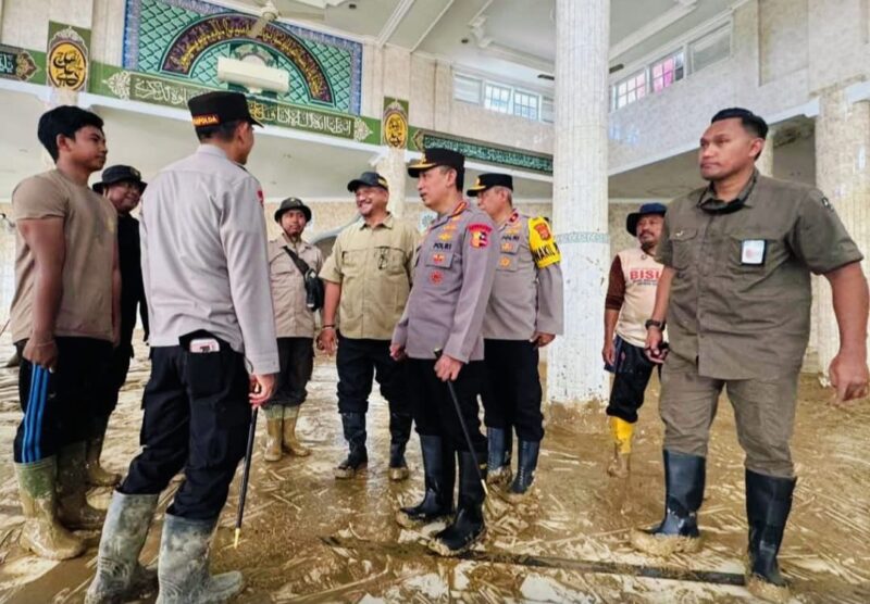 Personel Polri dan warga bersama-sama membersihkan Masjid Syuhada yang terdampak bencana.

