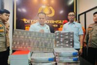 Petugas Ditreskrimsus Polda Jambi menunjukkan bukti uang negara yang berhasil diselamatkan dari kasus korupsi.