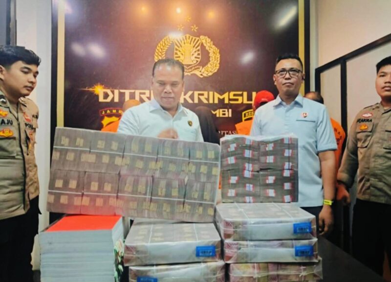 Petugas Ditreskrimsus Polda Jambi menunjukkan bukti uang negara yang berhasil diselamatkan dari kasus korupsi.