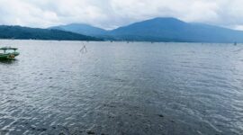 Panorama Danau Kerinci dengan latar jajaran Bukit Barisan yang membentang hijau, menampilkan keindahan alam khas Kabupaten Kerinci.