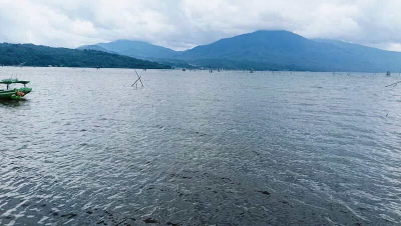 Panorama Danau Kerinci dengan latar jajaran Bukit Barisan yang membentang hijau, menampilkan keindahan alam khas Kabupaten Kerinci.