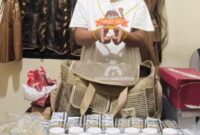 Tersangka RI memperlihatkan barang bukti ribuan obat keras ilegal yang disita dalam pengungkapan kasus peredaran obat tanpa izin di Kabupaten Lima Puluh Kota.