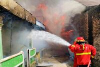 Petugas Dinas Pemadam Kebakaran Kota Padang berupaya memadamkan kebakaran yang menghanguskan rumah warga dan gedung SD di Surau Gadang, Jumat (6/2/2026).