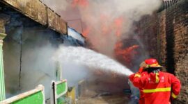 Petugas Dinas Pemadam Kebakaran Kota Padang berupaya memadamkan kebakaran yang menghanguskan rumah warga dan gedung SD di Surau Gadang, Jumat (6/2/2026).