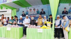 Wali Kota Alfin menyerahkan paket bahan pokok kepada warga saat Gerakan Pangan Murah di depan Gedung Nasional Sungai Penuh