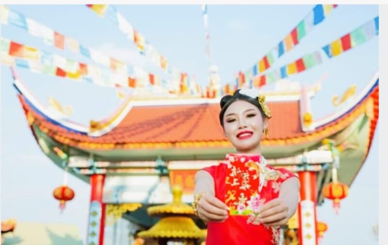 Suasana perayaan Tahun Baru Imlek dengan dekorasi merah dan tradisi pemberian angpao.