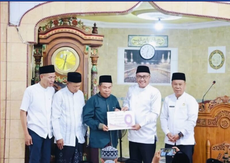 Wako Alfin menyerahkan bantuan secara simbolis kepada pengurus Masjid Madaniatul Islamiyah saat Safari Jum’at di Desa Sumur Anyir.