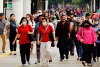 Suasana pekerja berjalan kaki di kawasan perkantoran menjelang periode libur dan cuti bersama Lebaran 2026.