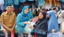 Ketua TP PKK Sri Kartini Alfin bersama Disperindag menyerahkan paket sembako kepada warga dalam kegiatan pasar murah di Sungai Penuh.