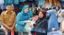Ketua TP PKK Sri Kartini Alfin bersama Disperindag menyerahkan paket sembako kepada warga dalam kegiatan pasar murah di Sungai Penuh.