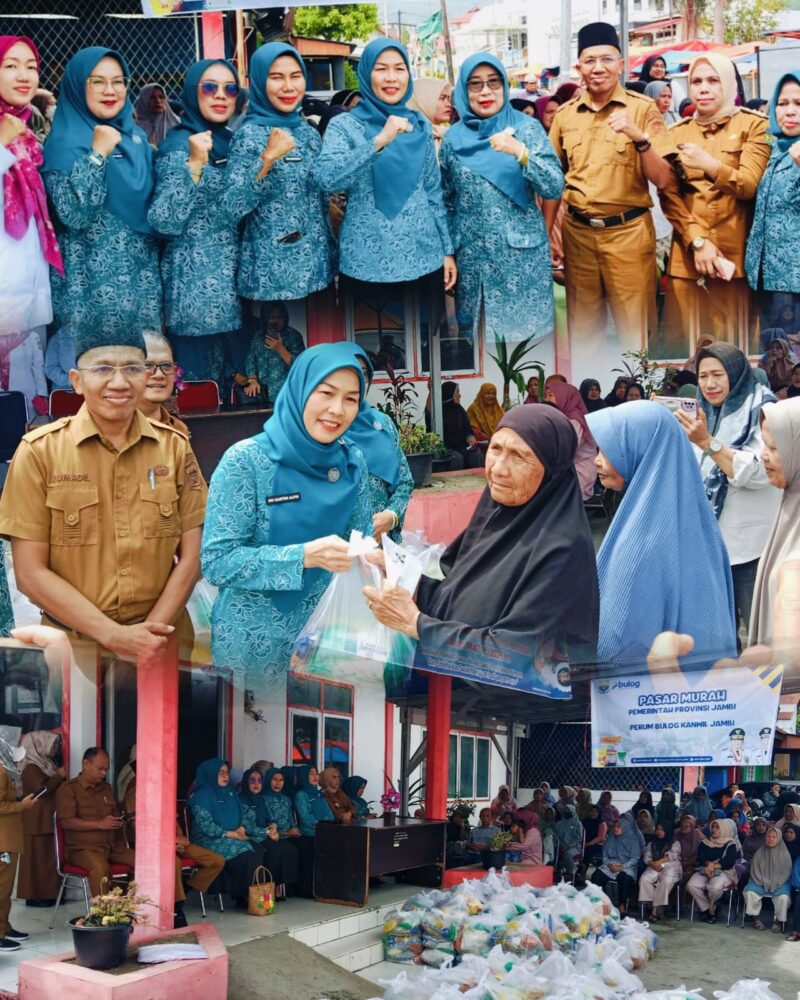 Ketua TP PKK Sri Kartini Alfin bersama Disperindag menyerahkan paket sembako kepada warga dalam kegiatan pasar murah di Sungai Penuh.