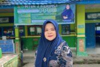 Kepala MTsN 2 Kerinci, Dra. Hj. Niswarti, M.Pd.I, berpose di halaman madrasah yang menjadi lokasi pembangunan gedung serba guna dari infak siswa dan dukungan guru.