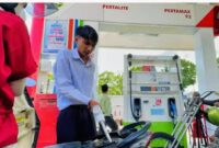 Petugas SPBU melayani pengisian BBM kepada pengendara.
