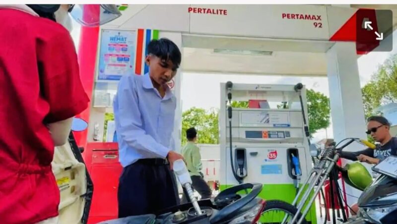 Petugas SPBU melayani pengisian BBM kepada pengendara.