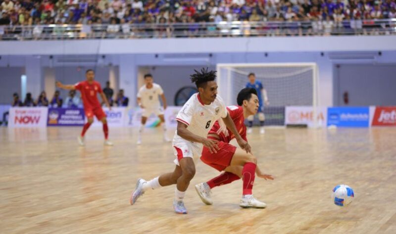 Pemain Timnas Futsal Indonesia berduel dengan pemain Thailand dalam laga sengit yang berakhir imbang 1-1 di babak pertama.