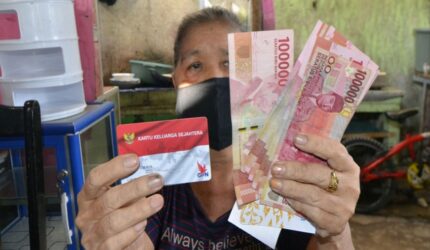 Warga menunjukkan Kartu Keluarga Sejahtera dan uang bantuan sosial dari pemerintah
